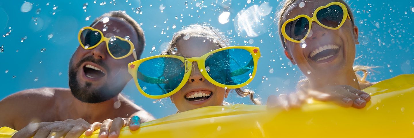 Family having fun on summer vacation. People jumping in swimming pool. Active lifestyle concept. Spring break!