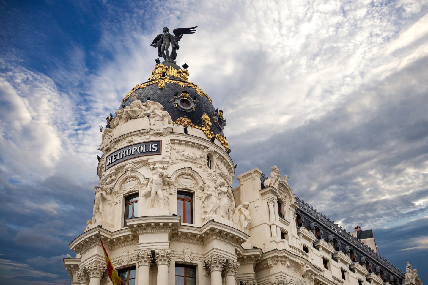 Metropolis - one of the most beautiful buildings in Madrid, Spain with dramatic blue cloudy sky on the background 
