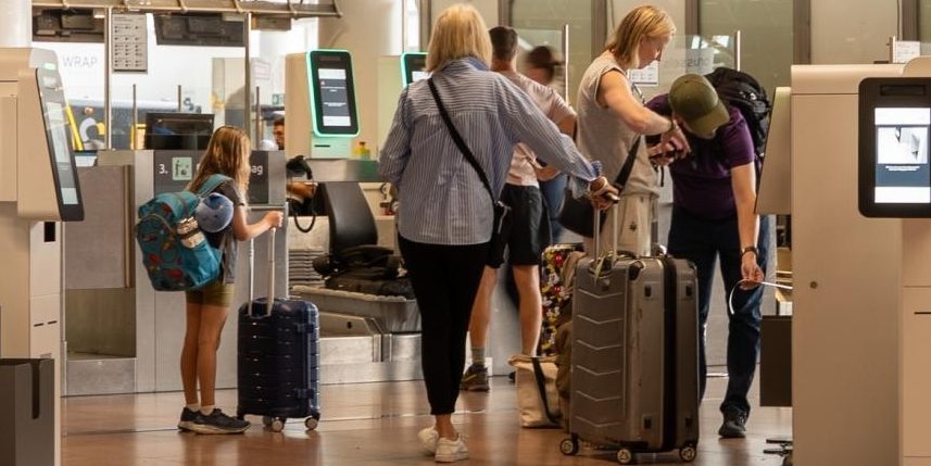 Travelers gathered at an airport, surrounded by luggage, preparing for their journeys.