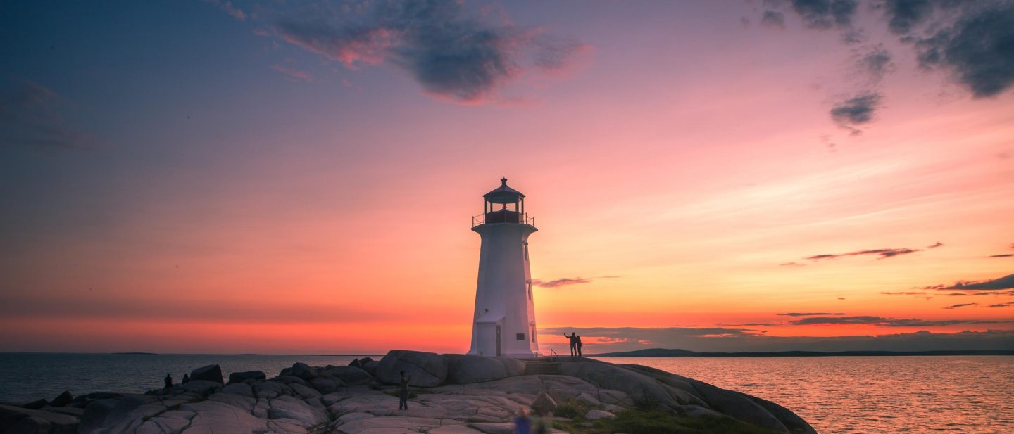 Lighthouse near Halifax at sunset, overlooking the Atlantic Ocean beneath a colorful evening sky.