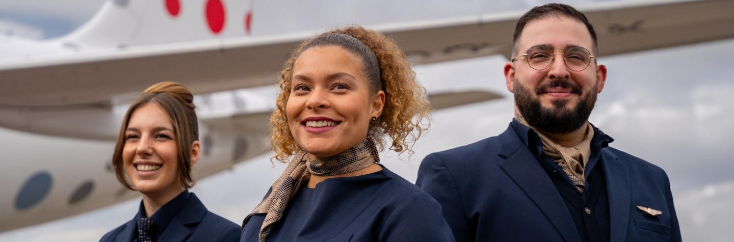 Drei Besatzungsmitglieder stehen vor einem von Brussels Airlines entworfenen Flugzeug