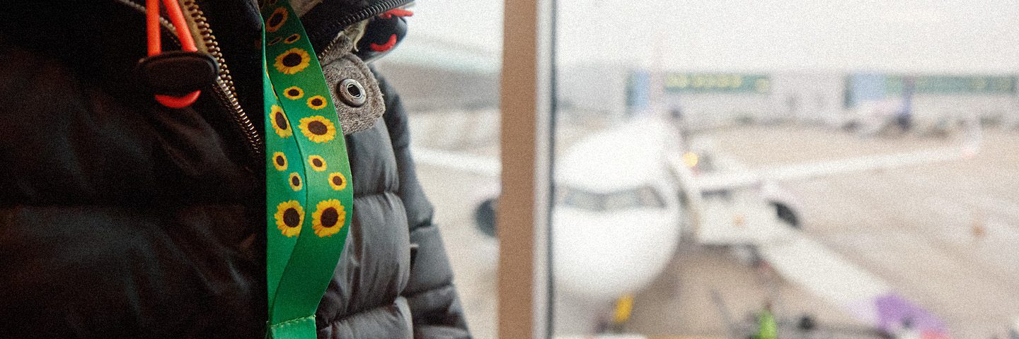 Person at an airport wearing a Hidden Disabilities Sunflower lanyard.