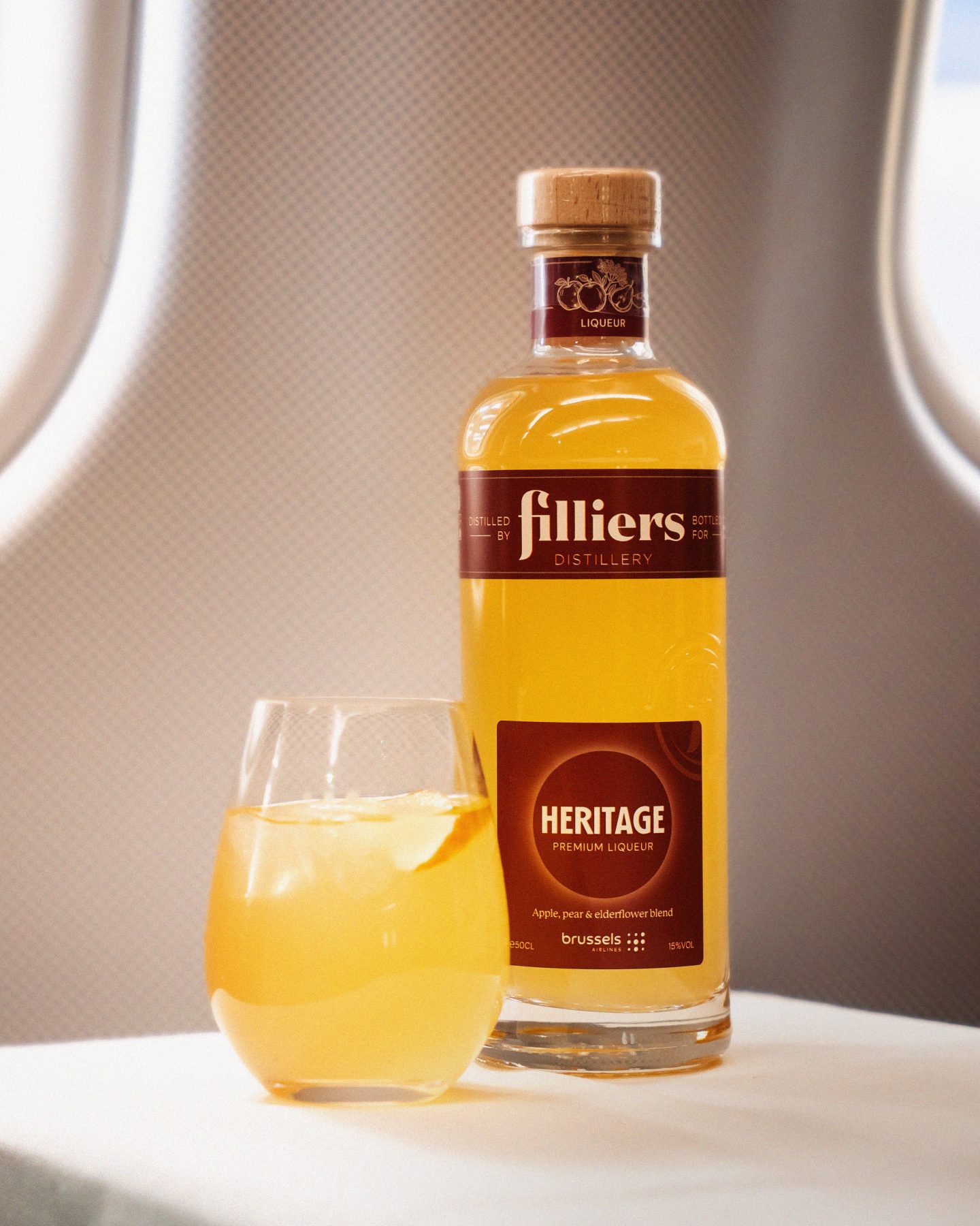 Filliers Heritage genever bottle and signature drink on an airplane tray.