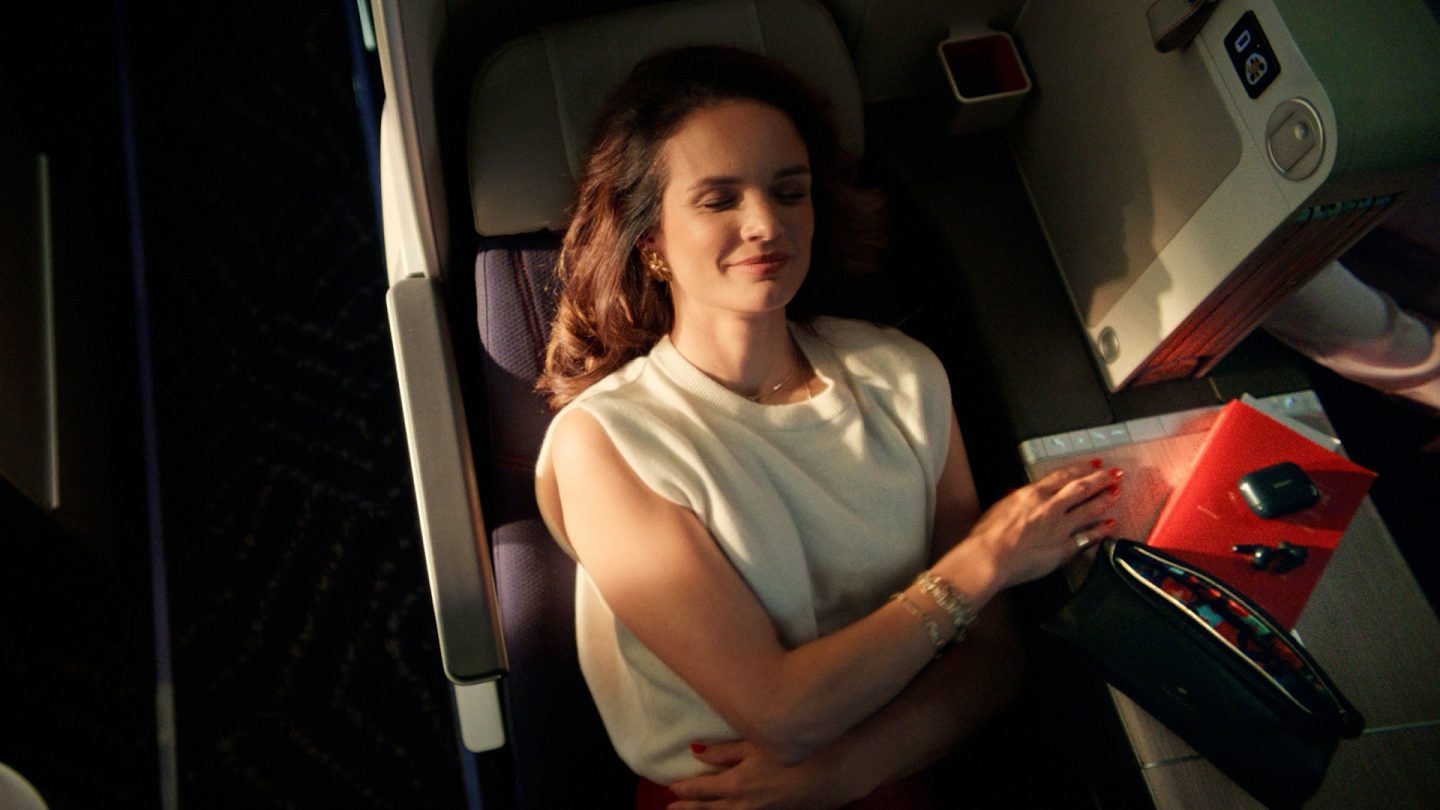 Woman relaxing in a lie-flat business class airplane seat.