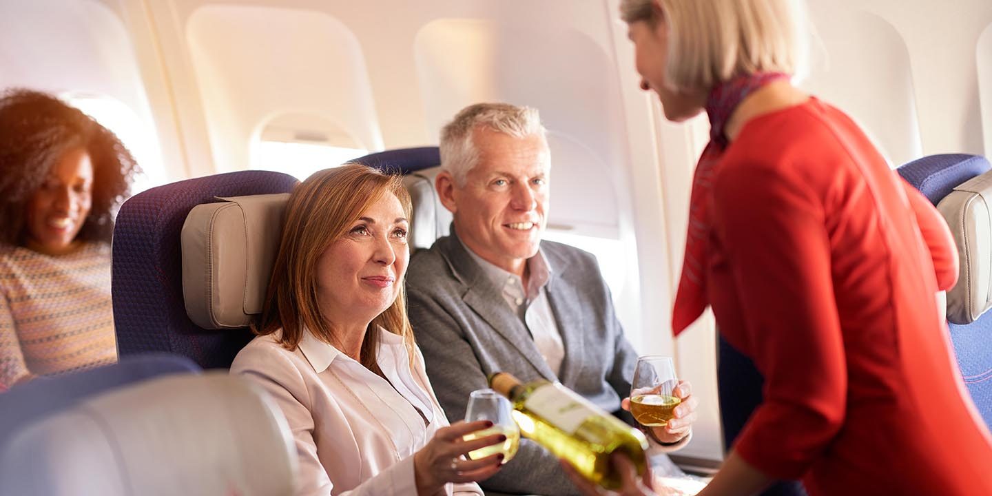 Flight crew serving wine at two passengers