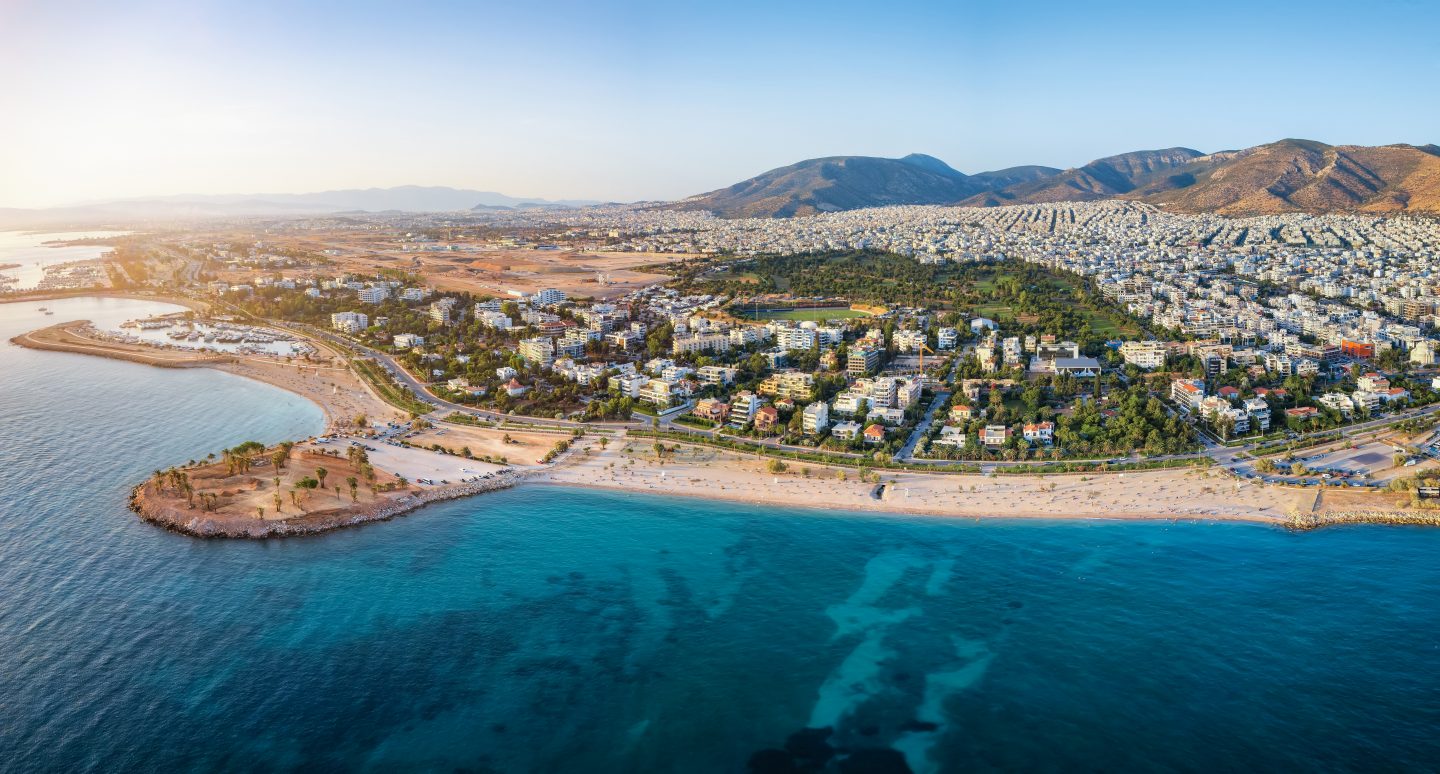 Aerial view of the coastline of Glyfada, south Athens, Greece, with beaches and marinas during summer sunset time